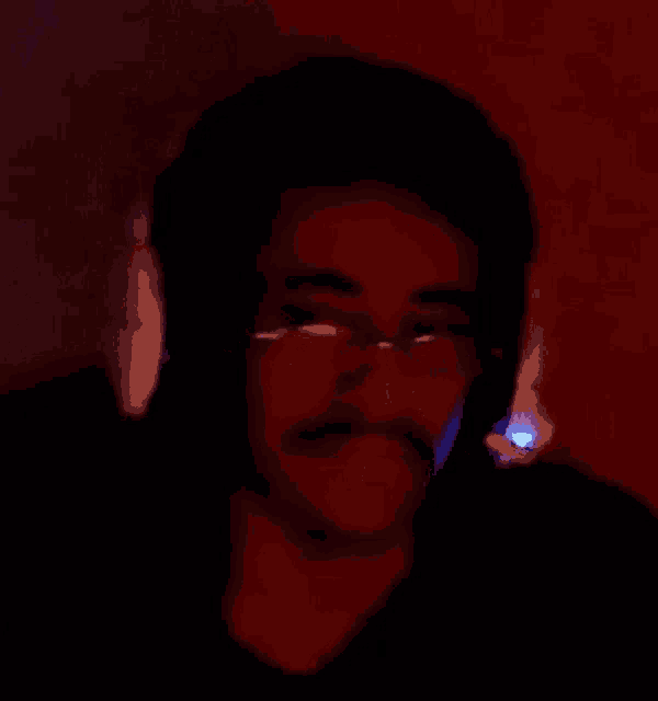 a man with glasses and a mustache wearing headphones