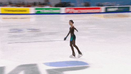 a woman is ice skating in front of a sign that says ' a '