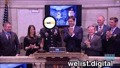 a group of people standing in front of a sign that says " welist.digital "