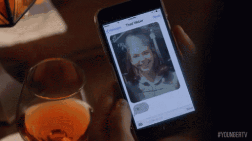 a person holding a cell phone with a picture of a woman on the screen