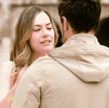 a man and a woman are looking at each other and the woman is smiling