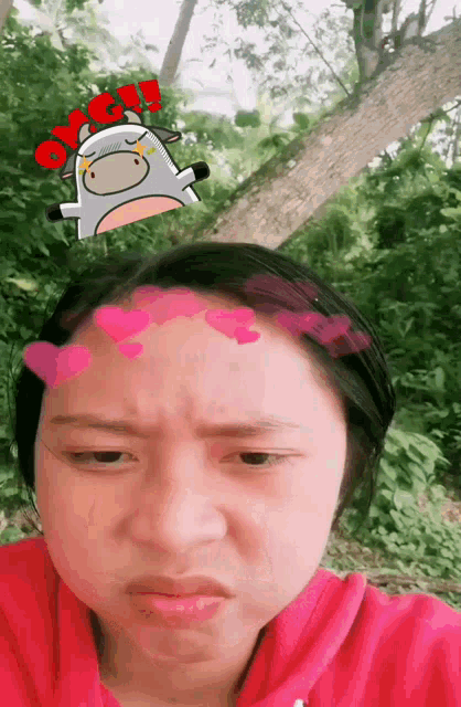 a girl with a sticker of a cow on her forehead with the word ok on it