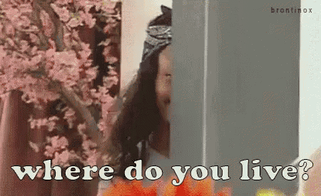 a woman is peeking out from behind a wall and says where do you live