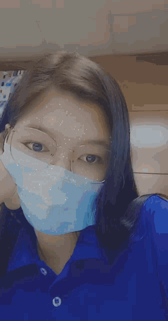 a girl wearing a blue shirt and a blue mask