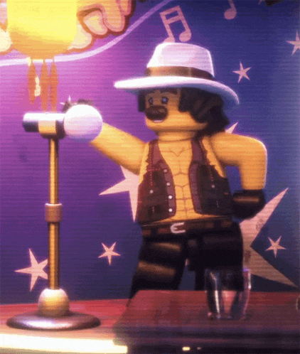 a lego man singing into a microphone with a note on his hat