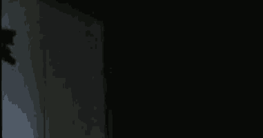 a shadow of a person is cast on a wall in the dark .