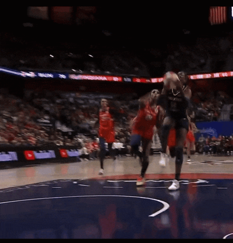 a basketball game is being played in a stadium with coca cola and state farm advertisements