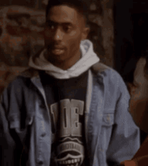 a man wearing a hoodie and a t-shirt that says ' uc ' on it