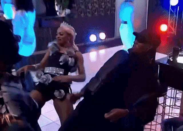 a woman wearing a crown is dancing with a man