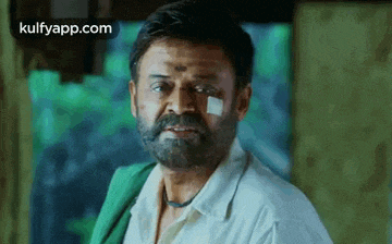 a man with a bandage on his face is looking at the camera .