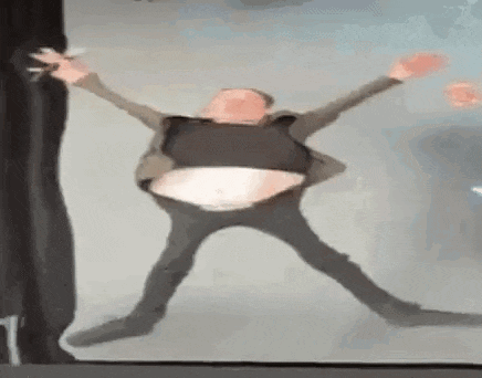 a man in a suit is dancing with his arms outstretched and a huge belly .