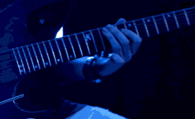 a person playing a guitar with the letter k on it