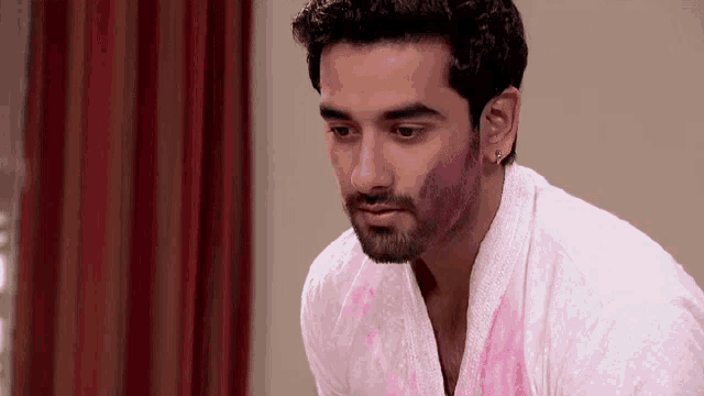 a man with a beard and a white shirt has pink paint on his face