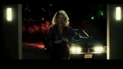 a poster for selena gomez shows a woman standing next to a car