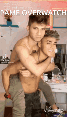 a shirtless man is carrying another shirtless man on his back in a room .