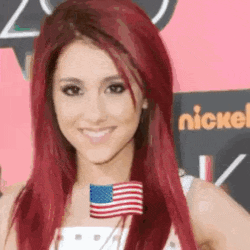 a woman with red hair is wearing an american flag pin