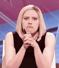 a woman is making a funny face with her hands folded .