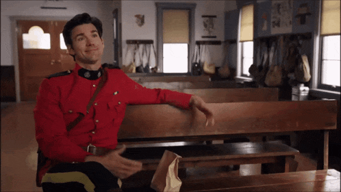 a man in a red uniform sitting on a bench