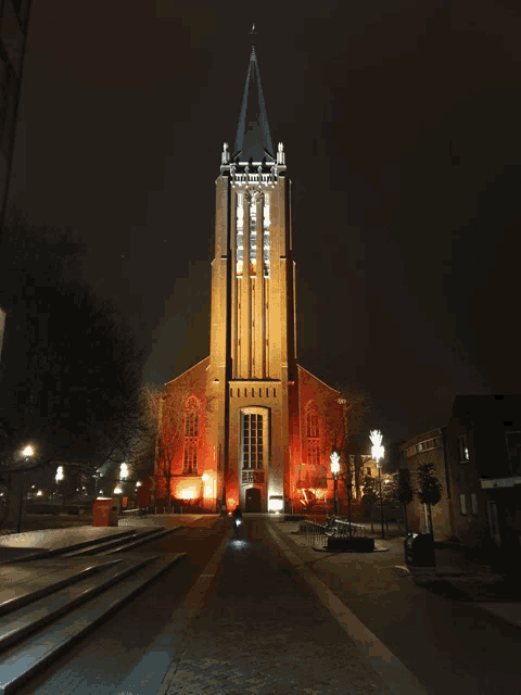 a church with a steeple lit up in orange