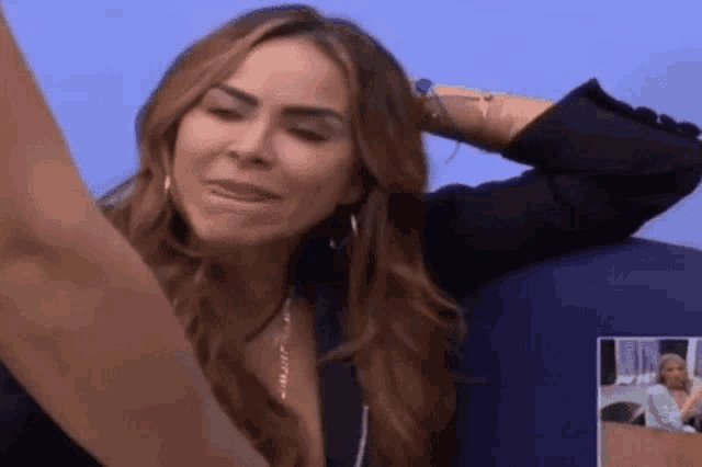 a woman with long hair is sitting on a blue couch .