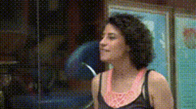 a woman wearing a pink necklace and a black tank top