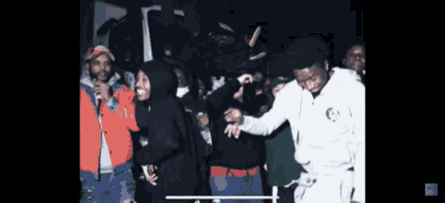 a group of people are gathered in a dark room and one of them is wearing a white sweatshirt with the word columbia on it
