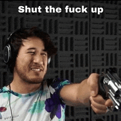a man wearing headphones is pointing a gun at the camera with the words shut the fuck up above him