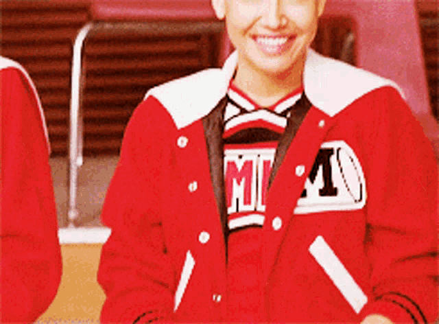 a cheerleader wearing a red jacket with the letter m on the front