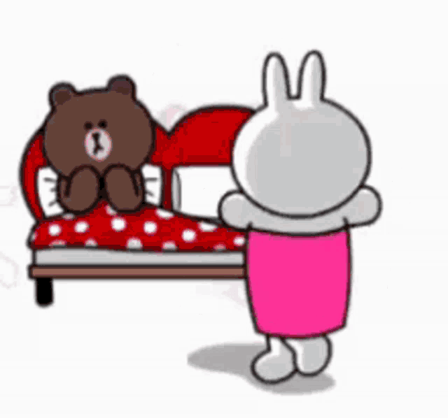 a brown bear and a white rabbit are sitting on a bed