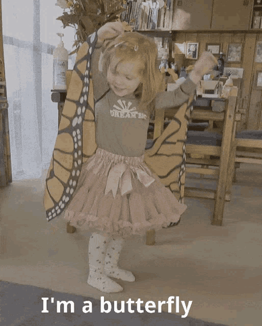 a little girl wearing a shirt that says ' i 'm a butterfly '