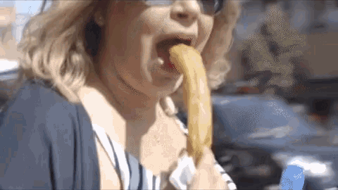 a woman is eating a very long french fry