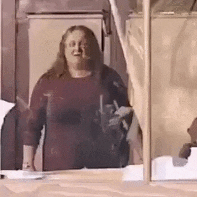 a woman in a red shirt is standing in front of a glass door .
