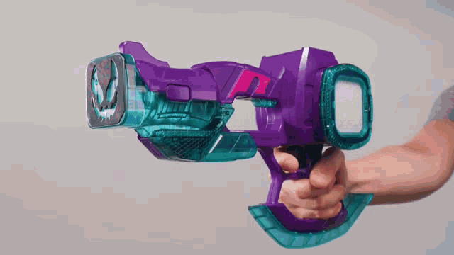 a close up of a person holding a purple and blue toy