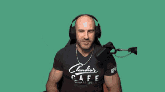 a man wearing headphones and a claudio cafe shirt