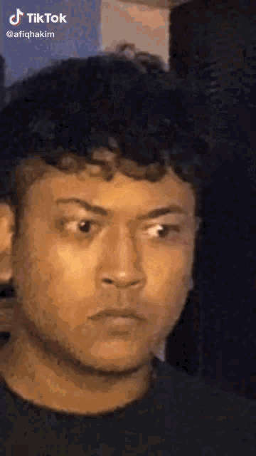 a close up of a man 's face with a tiktok logo on the bottom