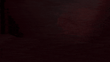 a cross is lit up in a dark room with a red background