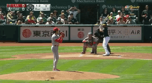 a baseball game is being played in front of a mechanics bank ad