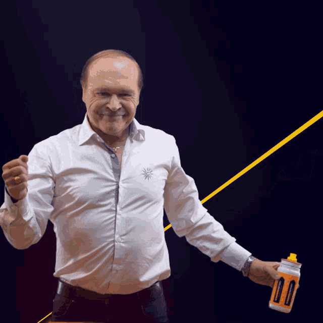 a man wearing a white shirt is holding a bottle of orange liquid that says ' energy drink ' on it