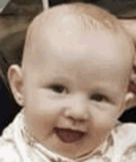 a close up of a baby 's face with a smile on it .