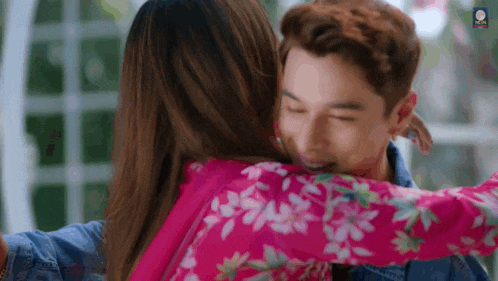 a man and a woman are hugging each other .