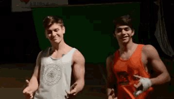 two men are standing next to each other in front of a green screen