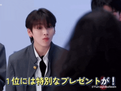 a young man in a suit and tie is talking to another man in a foreign language