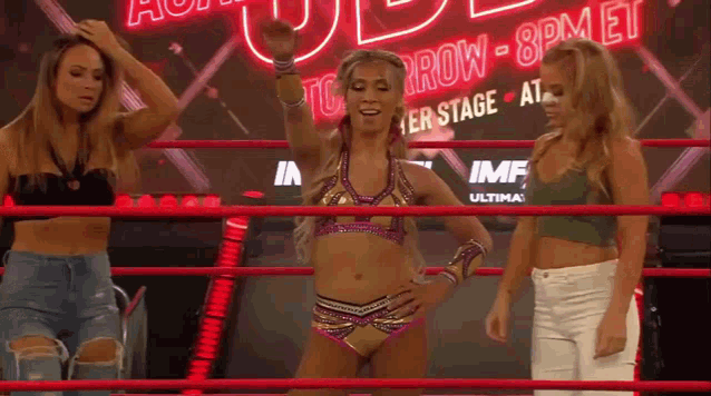 a woman in a wrestling ring with a sign that says tomorrow 8 pm et