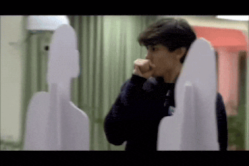 a man is standing in front of a cardboard cutout of a person