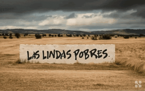 a sign that says las lindas pobres is in a field