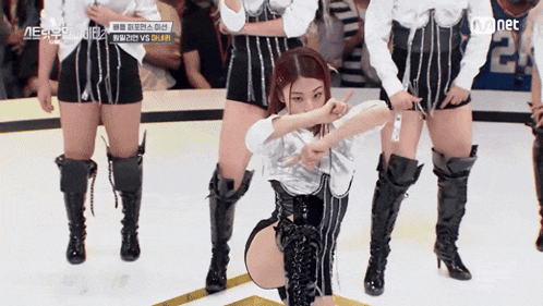 a group of women are dancing in front of a crowd and the word mnet is on the screen