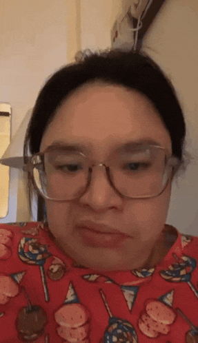 a woman wearing glasses and a red sweater with ice cream cones on it