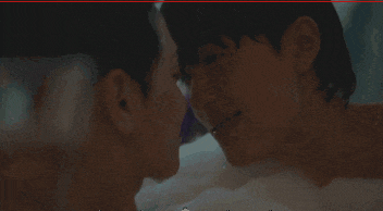 two men are kissing in a bathtub with bubbles coming out of it