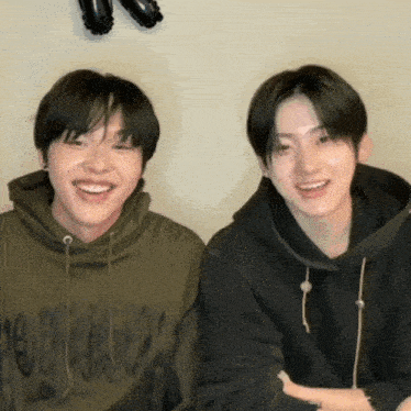 two young men wearing hoodies one of which has the word hoodie on the front
