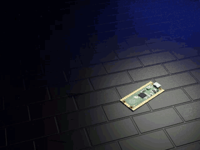 a small electronic device is on a black brick floor
